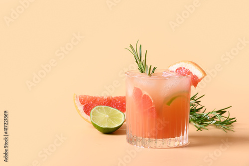 Foto Grapefruit soda with lime garnish rosemary sprig on color beige background