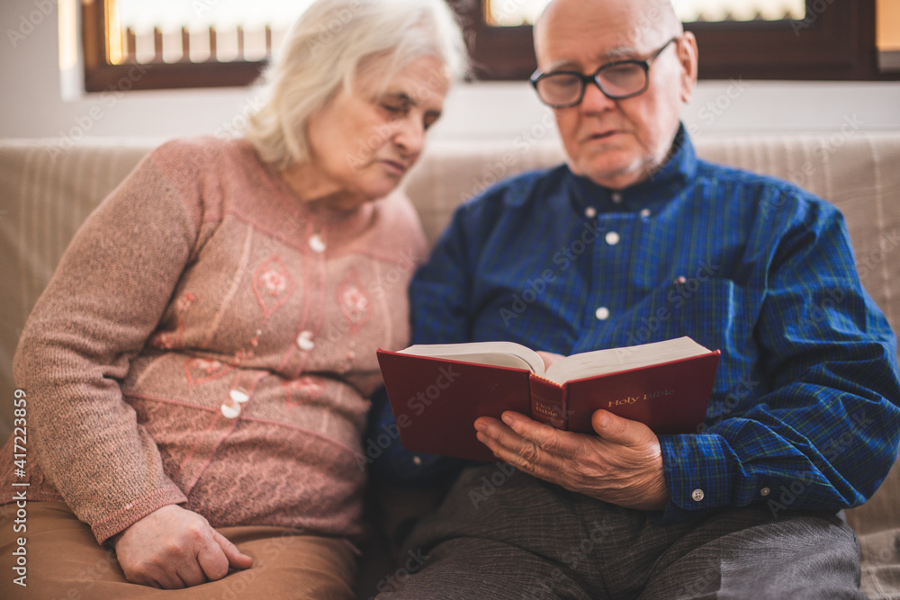 Elderly couple reading bible and pray together at home. Elderly couple reading bible and pray together at home.