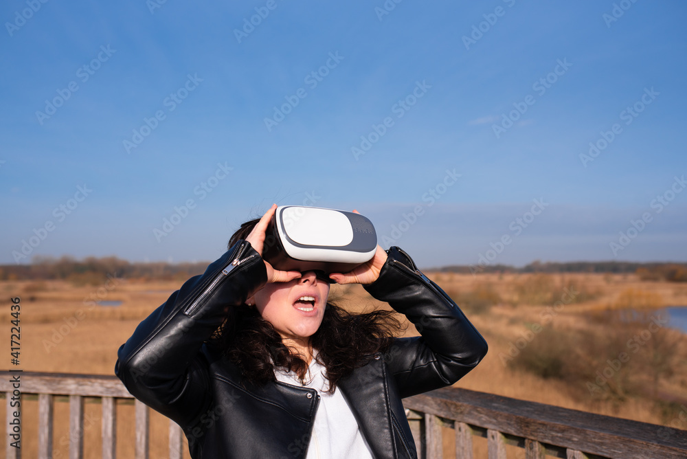 young woman looking through VR glasses