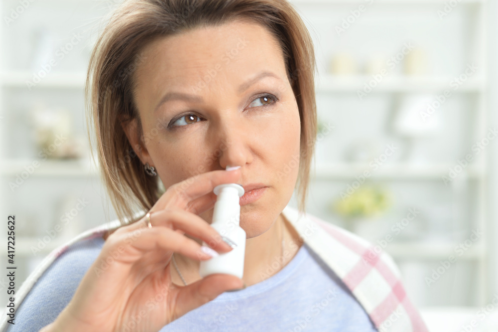 ill young woman with tapped nose using nasal spray ill young woman with tapped nose using nasal spray