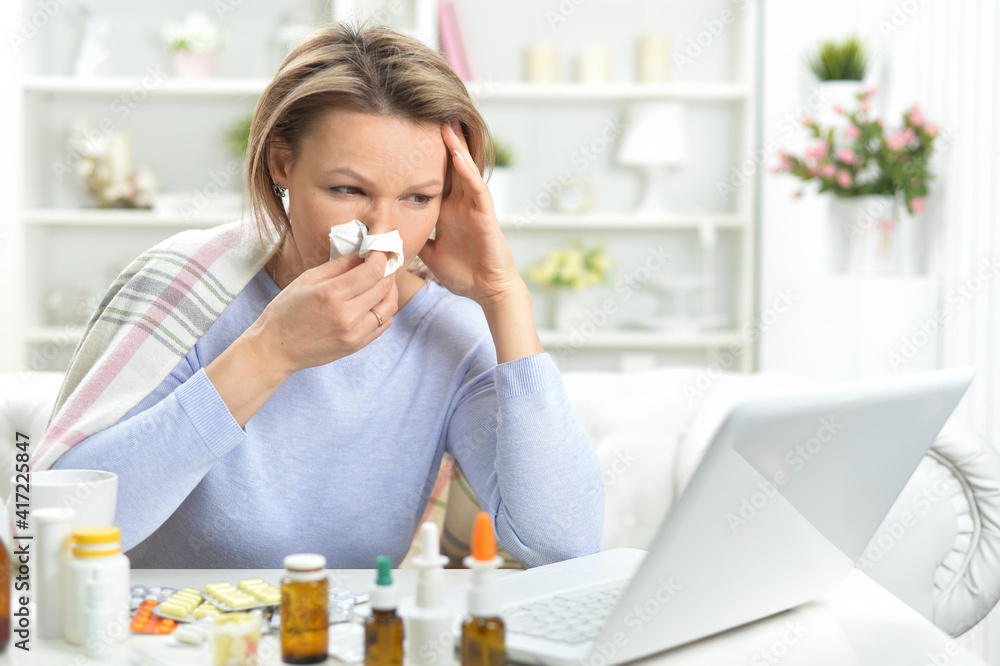 beautiful young woman with pills using laptop beautiful young woman with pills using laptop