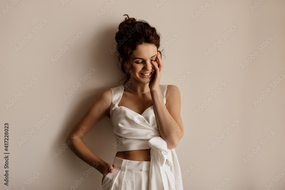 Charming cute lady laughing and covering face over isolated background. Carefree female model in stylish outfit celebrating woman's day Charming cute lady laughing and covering face over isolated background. Carefree female model in stylish outfit celebrating woman's day