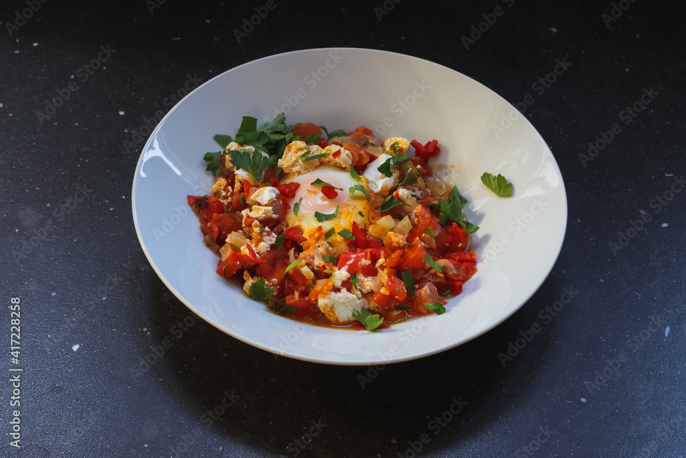 Shakshuka With Feta on a plate, dark background Shakshuka With Feta on a plate, dark background