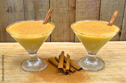 Boza and cinnamon sticks, traditional Turkish cuisine drinks, on wooden background photo