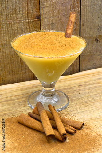 Boza and cinnamon sticks, traditional Turkish cuisine drinks, on wooden background photo