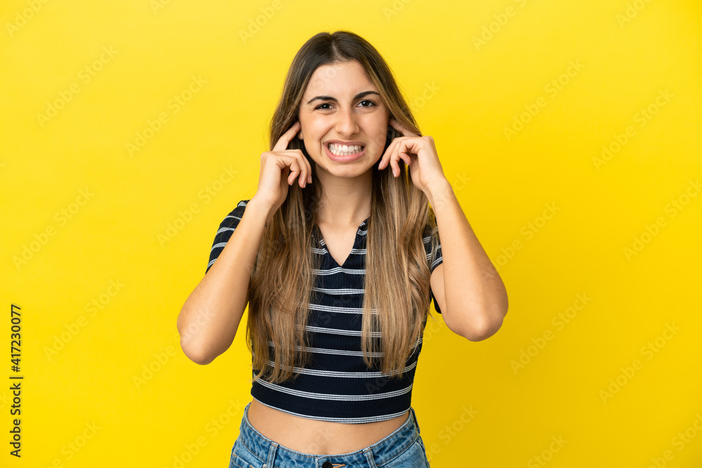 Young caucasian woman isolated on yellow background frustrated and covering ears Young caucasian woman isolated on yellow background frustrated and covering ears