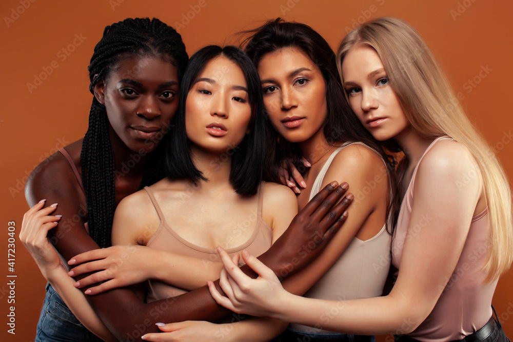 Obraz premium young pretty asian, caucasian, afro woman posing cheerful together on brown background, lifestyle diverse nationality people concept