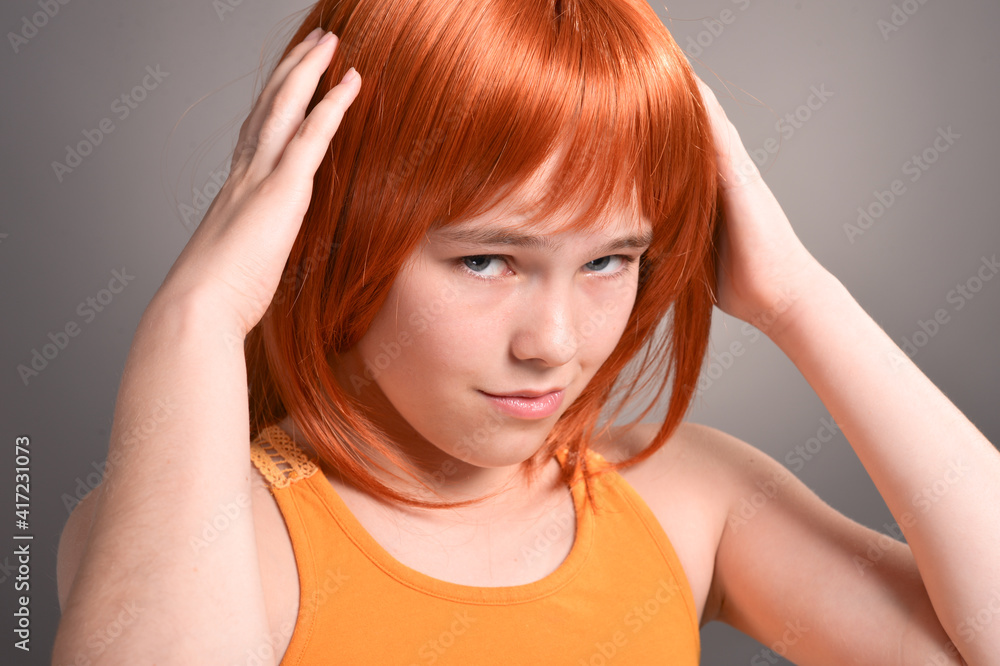 Fototapeta premium Portrait of cute girl with red hair posing in studio