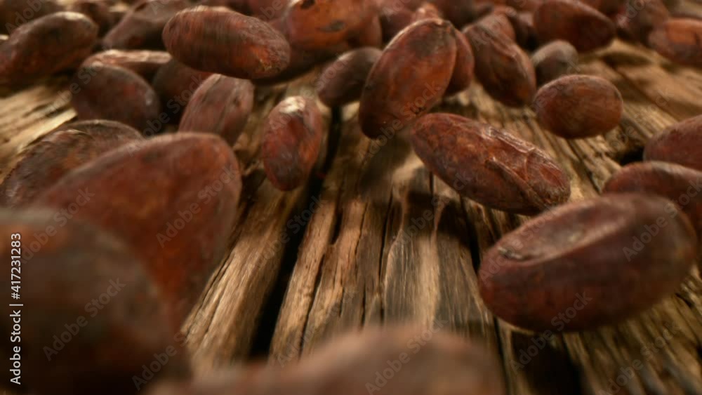 Super slow motion of falling group of cocoa beans on wood, camera follow. Filmed on high speed cinema camera, 1000fps. Super slow motion of falling group of cocoa beans on wood, camera follow. Filmed on high speed cinema camera, 1000fps.