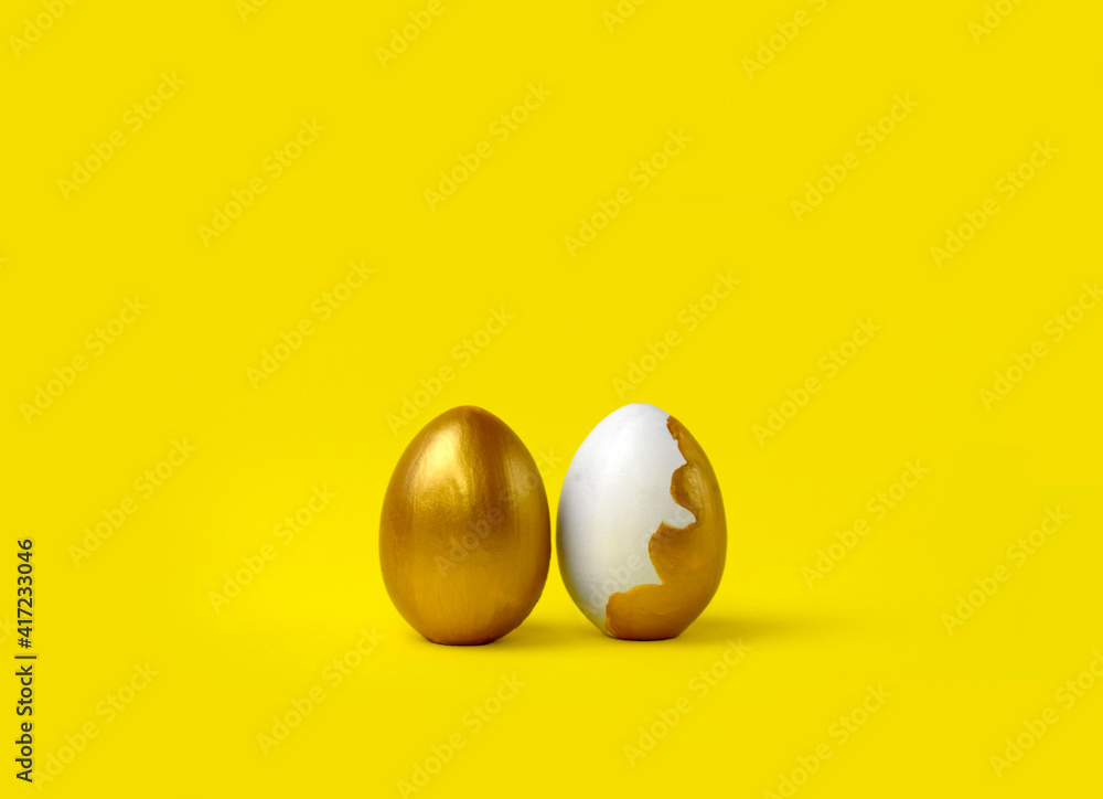 Minimalist Easter composition. Couple of golden painted eggs in row on yellow background. Trendy color concept. Happy Easter greeting card with copyspace. Minimalist Easter composition. Couple of golden painted eggs in row on yellow background. Trendy color concept. Happy Easter greeting card with copyspace.