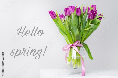 A bouquet of tulips in a vase. Banner hello spring . Lilac tulips. New season. Spring. Hi, Mart. Flowers in a vase.