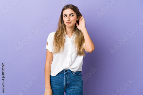 Young woman over isolated purple background having doubts