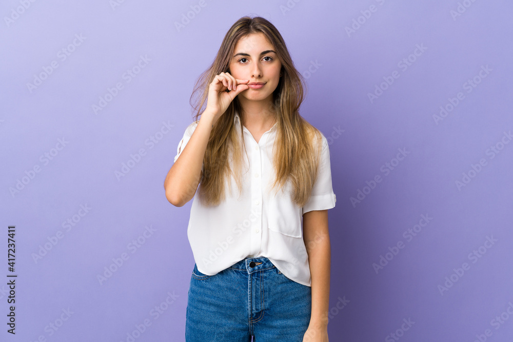Young woman over isolated purple background showing a sign of silence gesture Young woman over isolated purple background showing a sign of silence gesture