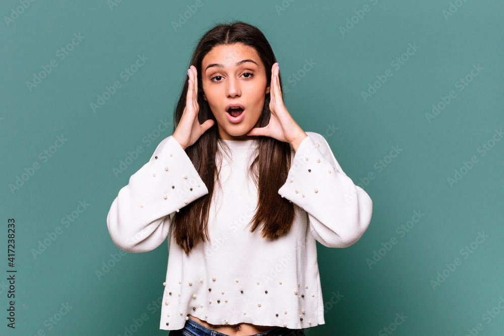 Young Indian woman isolated on blue background surprised and shocked. Young Indian woman isolated on blue background surprised and shocked.