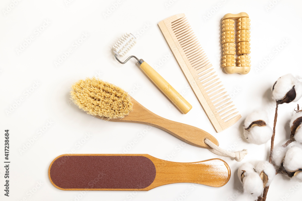 Fototapeta premium Natural wooden bath accessories for care, massage brush, hair comb, massagers, pedicure file on a light background, top view. Plastic-free, eco-friendly life.