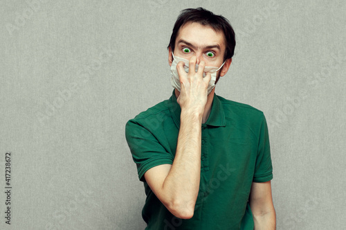 Photography man in panic trying tear off a medical mask