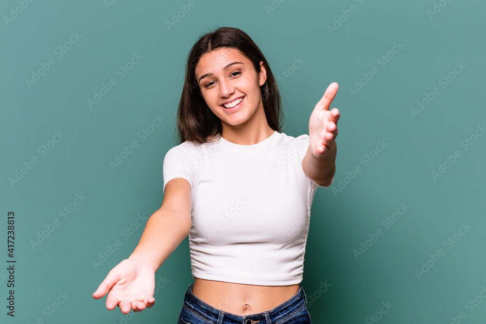 Young Indian woman isolated on blue background showing a welcome expression. Young Indian woman isolated on blue background showing a welcome expression.