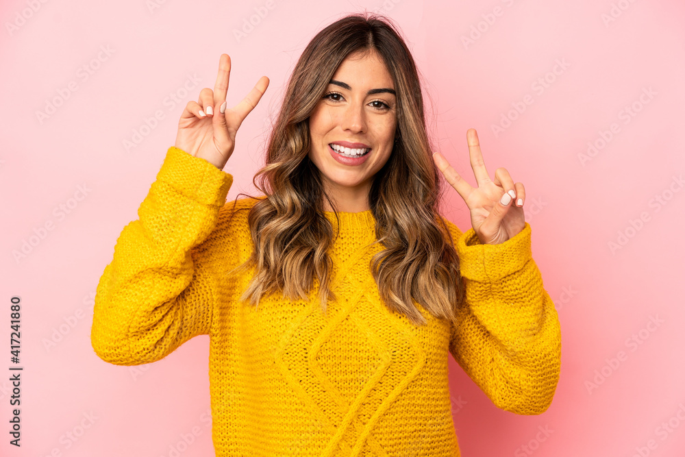 Young caucasian woman isolated showing victory sign and smiling broadly.