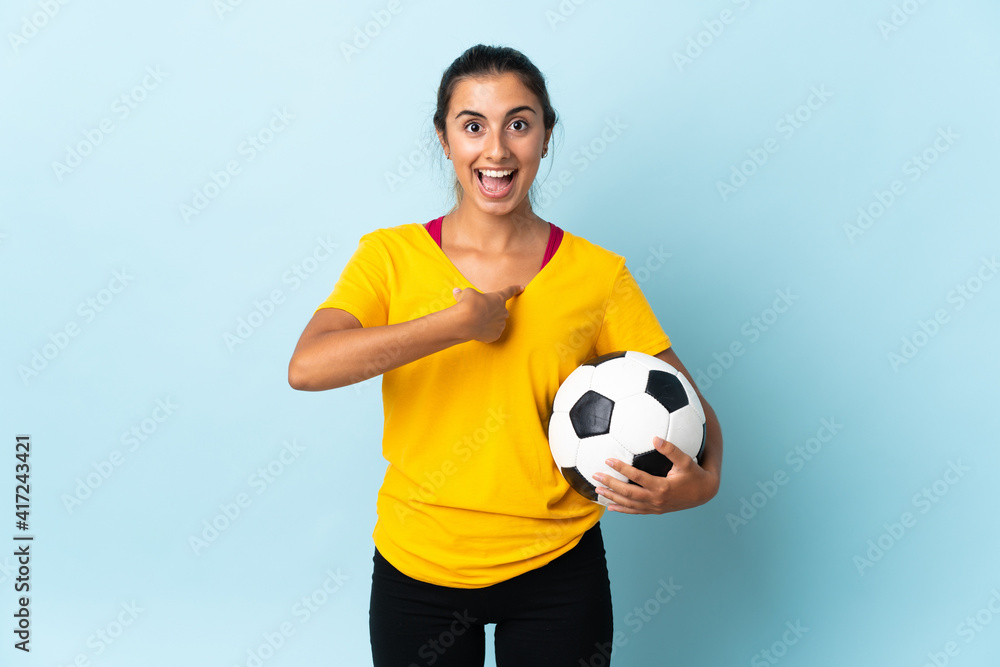Young hispanic football player woman over isolated on blue background with surprise facial expression Young hispanic football player woman over isolated on blue background with surprise facial expression