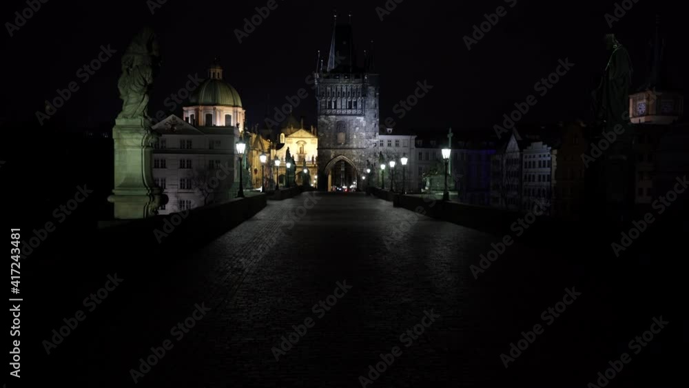 lanterns and statue on Charles Bridge and in the background two stone towers at night in the old town of Prague and in the background lanterns and statue on Charles Bridge and in the background two stone towers at night in the old town of Prague and in the background