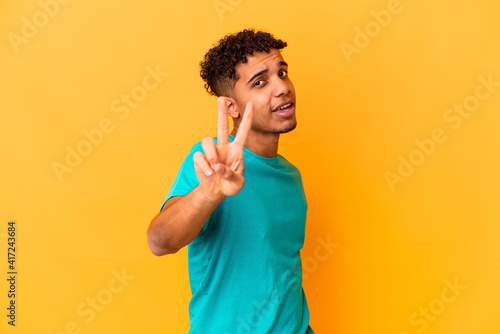 Young african american curly man isolated on purple showing number two with fingers.