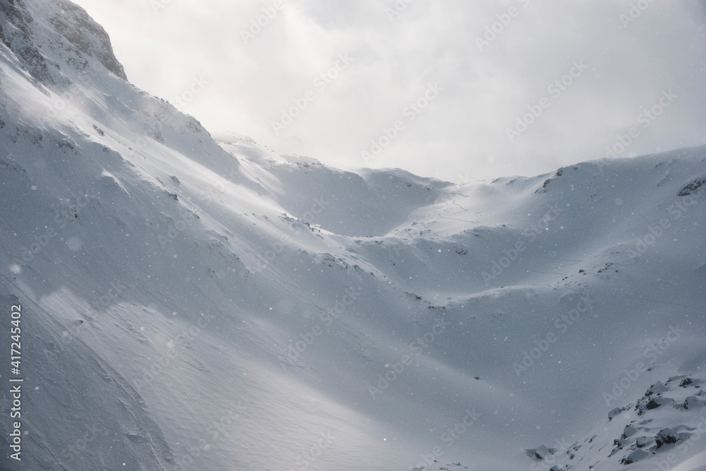 Misterious light and shadow while snow falling on ski touring tracks in austrian mountain range montafon