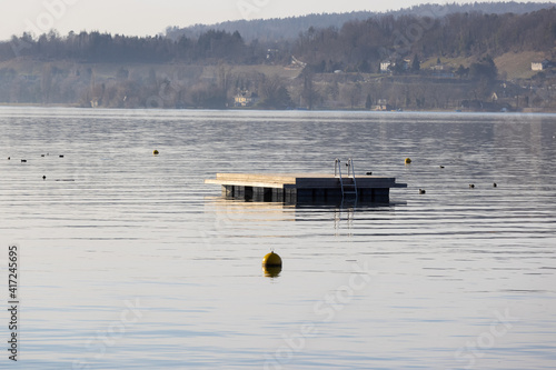empty swimming platform without bathers on a calm lake at dawn, without people, in the daytime