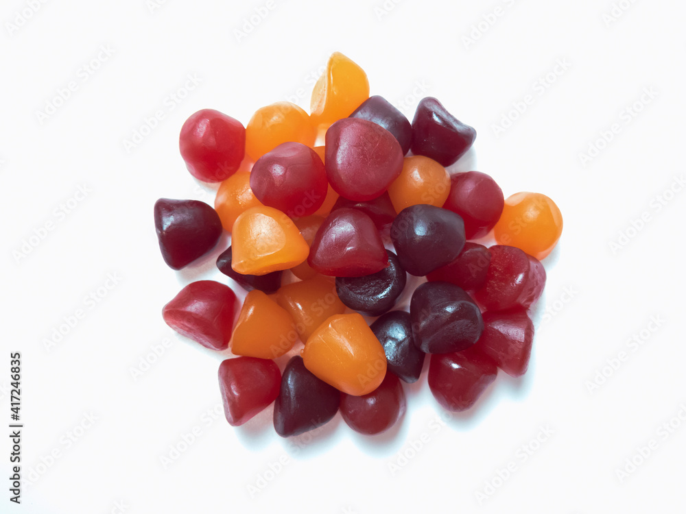 Close-up texture of red, orange and purple multivitamin gummies on white background. Healthy lifestyle concept.. Close-up texture of red, orange and purple multivitamin gummies on white background. Healthy lifestyle concept..