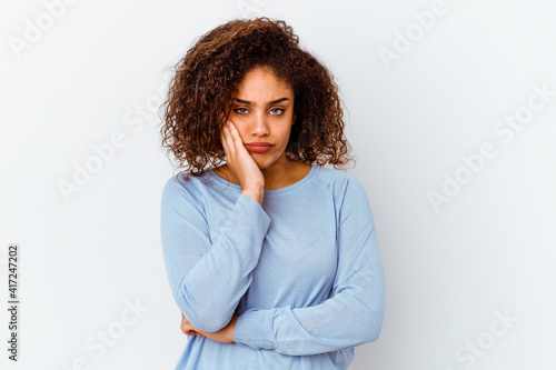 Young african american woman isolated on white background blows cheeks, has tired expression. Facial expression concept.