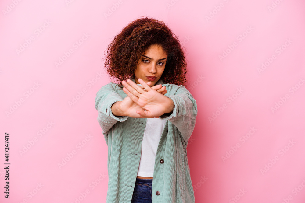 Young african american woman isolated on pink background standing with outstretched hand showing stop sign, preventing you. Young african american woman isolated on pink background standing with outstretched hand showing stop sign, preventing you.