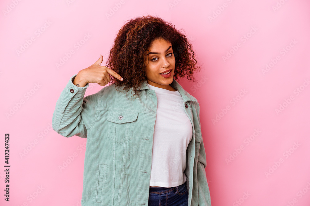 Young african american woman isolated on pink background person pointing by hand to a shirt copy space, proud and confident Young african american woman isolated on pink background person pointing by hand to a shirt copy space, proud and confident