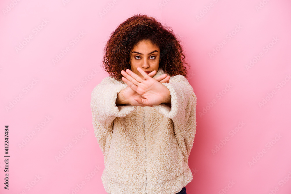 Young african american woman isolated on pink background doing a denial gesture Young african american woman isolated on pink background doing a denial gesture