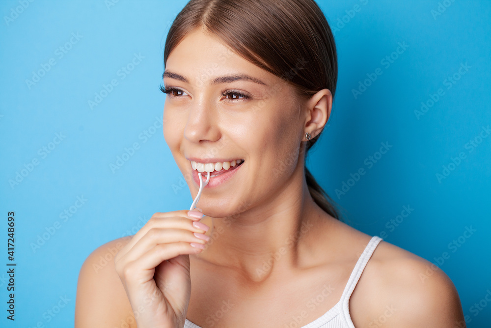 Portrait of beautiful woman cleaning teeth with dental floss Portrait of beautiful woman cleaning teeth with dental floss