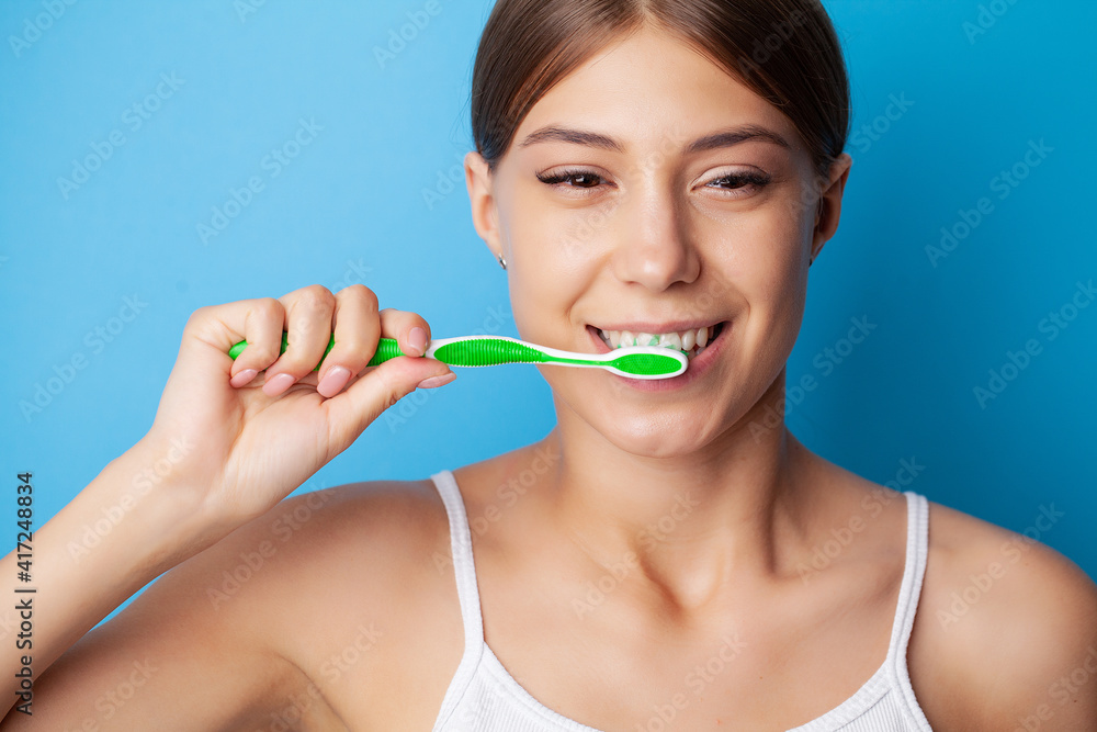 Yooung woman brushing her teeth at mirror Yooung woman brushing her teeth at mirror