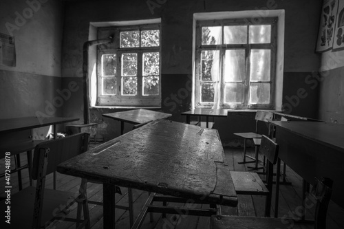 Old and abandoned school classroom interior, in black and white. photo