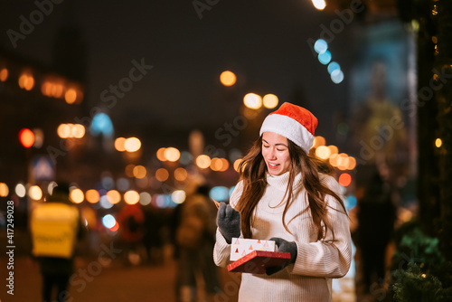 Night street portrait of young beautiful woman acting thrilled.