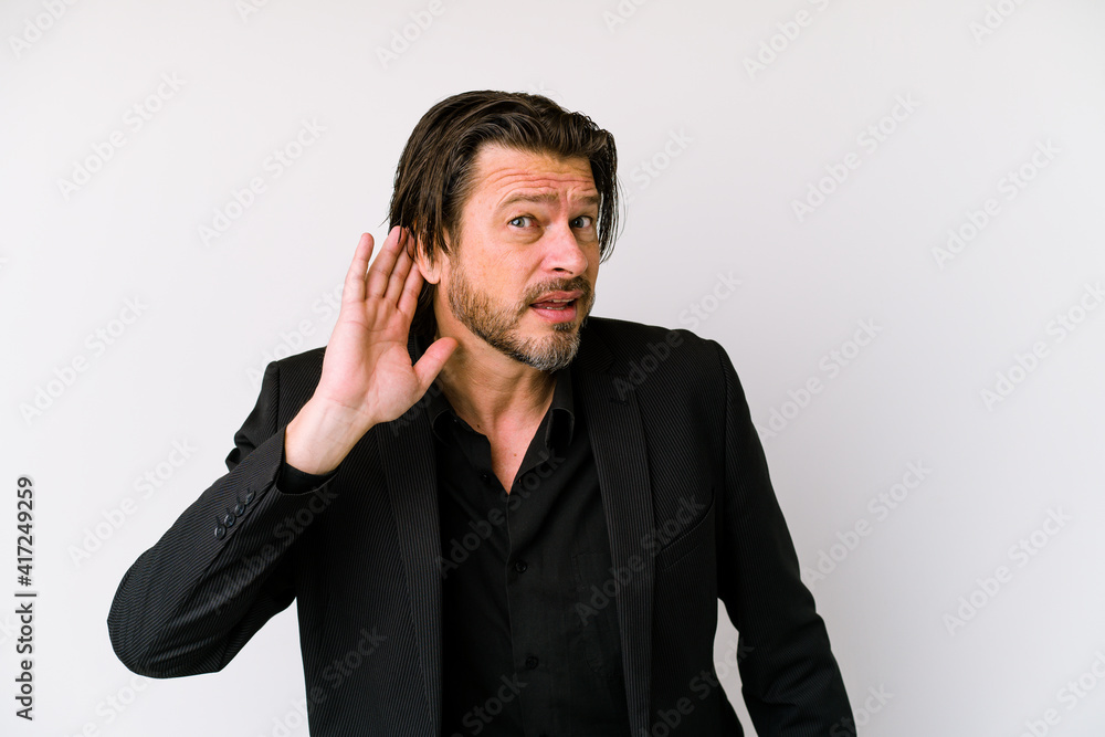 Middle age business dutch man isolated on white background trying to listening a gossip. Middle age business dutch man isolated on white background trying to listening a gossip.