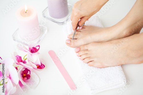 Cozy home spa, young woman doing pedicure on her feet nails.