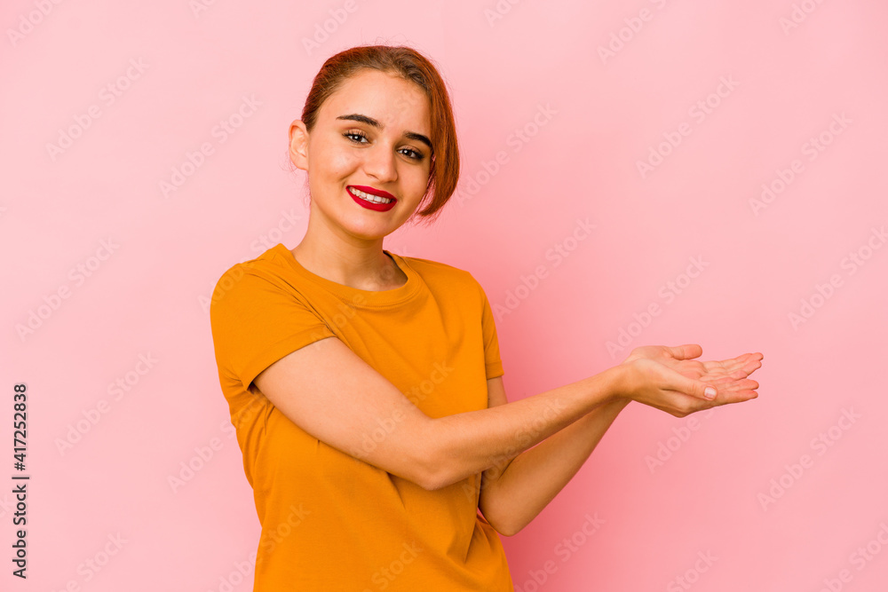 Obraz premium Young arab mixed race woman holding a copy space on a palm.