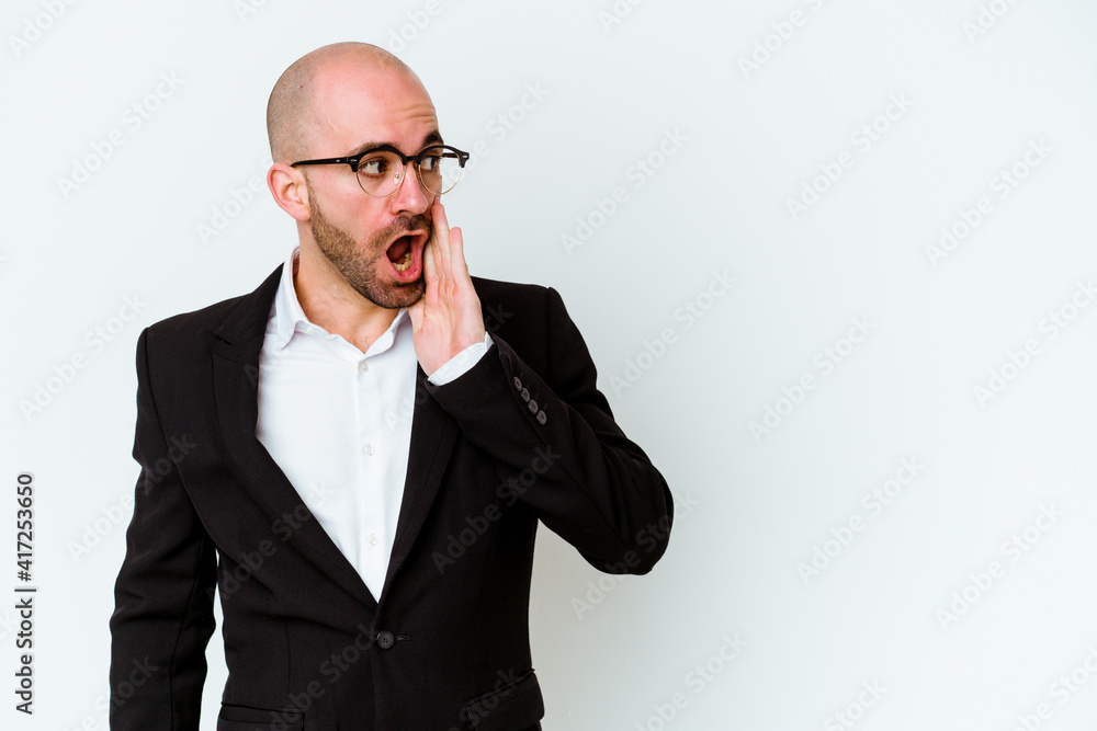 Young business caucasian bald man isolated on blue background is saying a secret hot braking news and looking aside Young business caucasian bald man isolated on blue background is saying a secret hot braking news and looking aside
