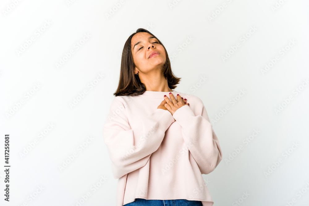 Young mixed race woman has friendly expression, pressing palm to chest. Love concept. Young mixed race woman has friendly expression, pressing palm to chest. Love concept.