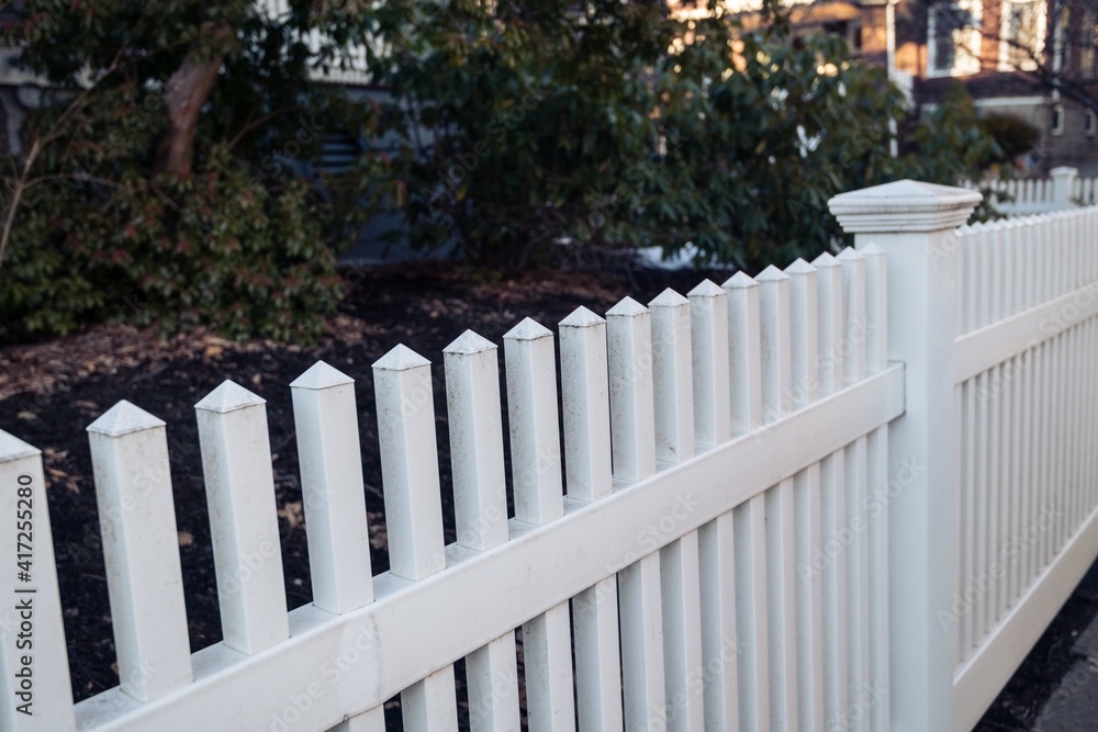 White picket fence in South Boston neighborhood with homes and condo buildings