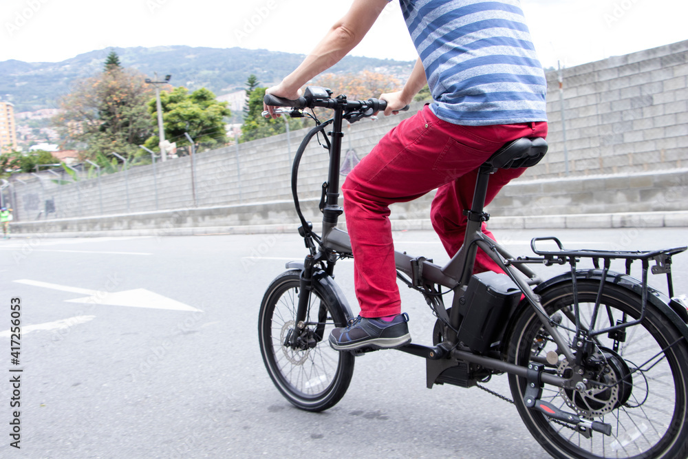 Obraz premium Man driving electric bike to work in medellin
