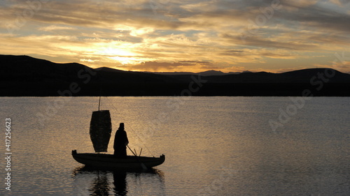balsa con hombre andino en lago titicaca