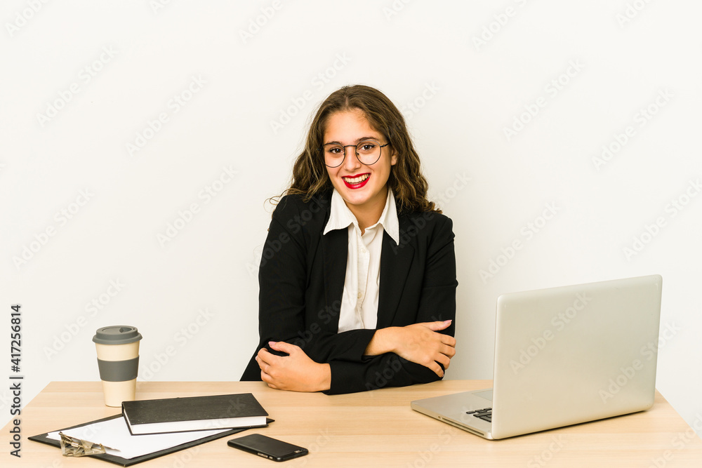 Young caucasian business woman working on her desktop isolated happy, smiling and cheerful. Young caucasian business woman working on her desktop isolated happy, smiling and cheerful.
