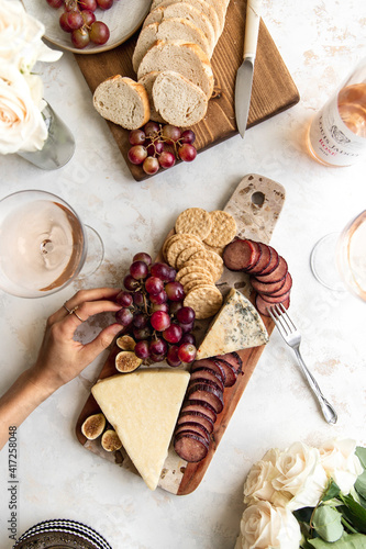 Fall cheeseboard with hand in frame and rose. photo