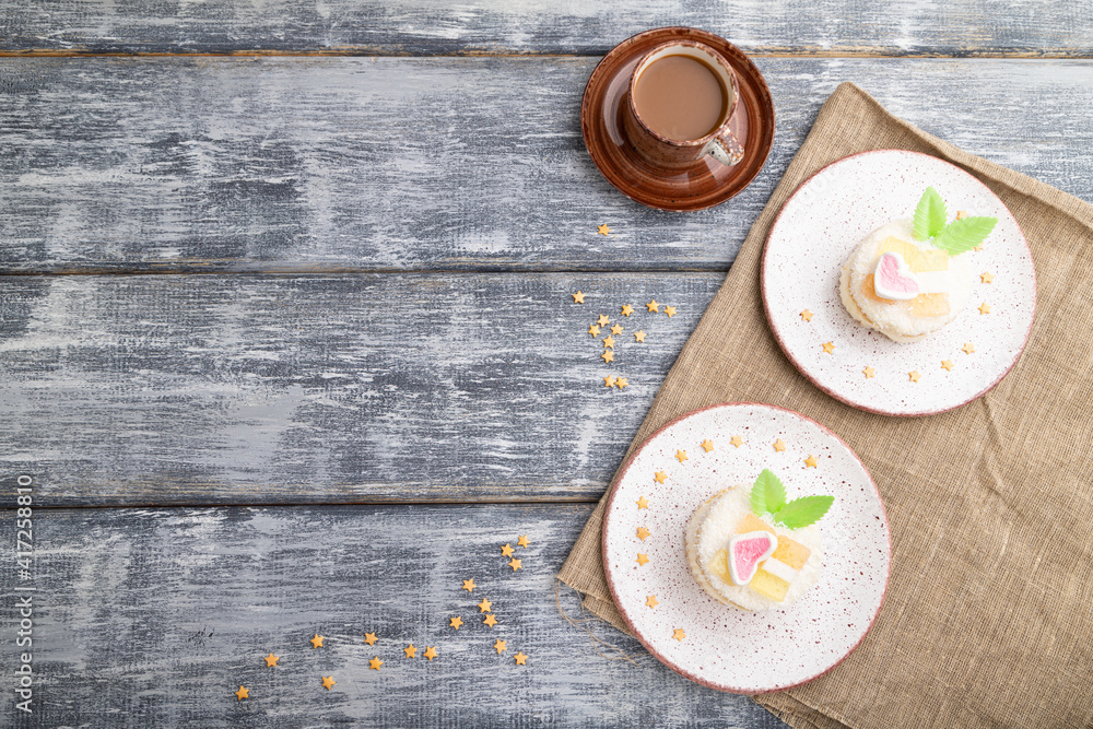 Decorated cake with milk and coconut cream with cup of coffee on a gray wooden background. top view, copy space. Decorated cake with milk and coconut cream with cup of coffee on a gray wooden background. top view, copy space.