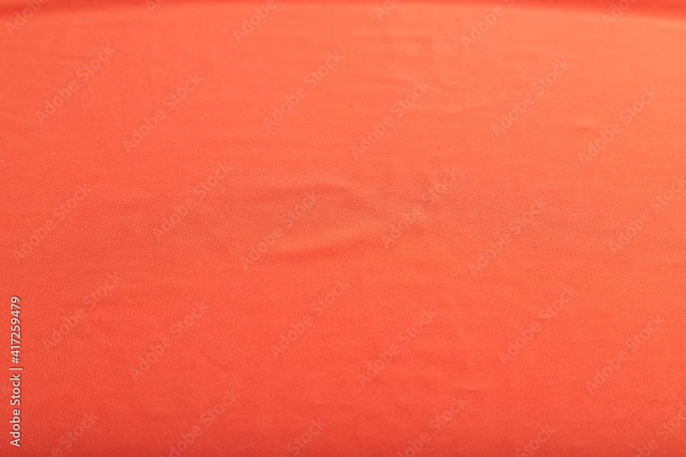 Fototapeta premium Fragment of smooth red silk tissue. Top view, natural textile background.