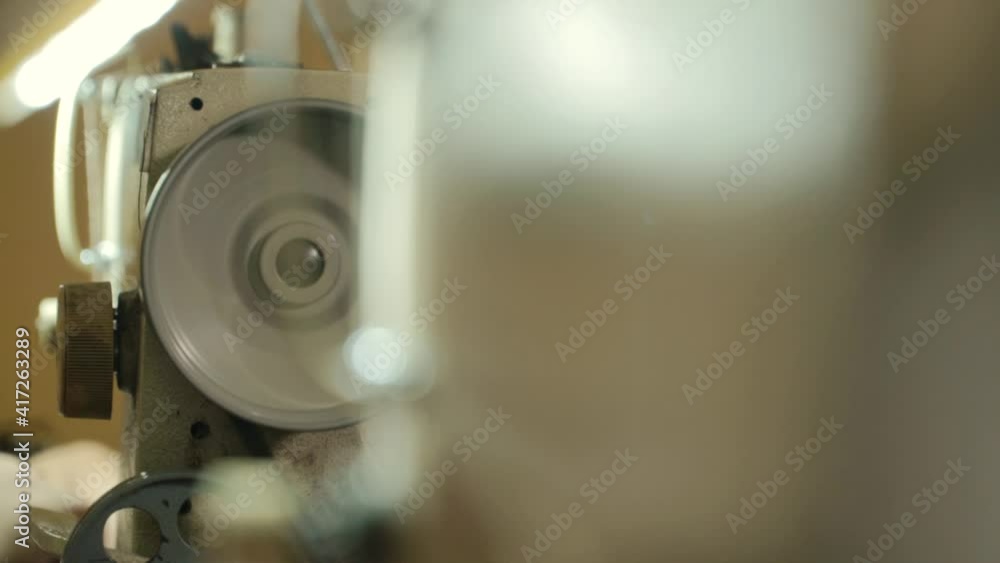 Sewing machine at work. Worker had operating a sewing machine wheel. Shallow depth of field. Sewing machine at work. Worker had operating a sewing machine wheel. Shallow depth of field.