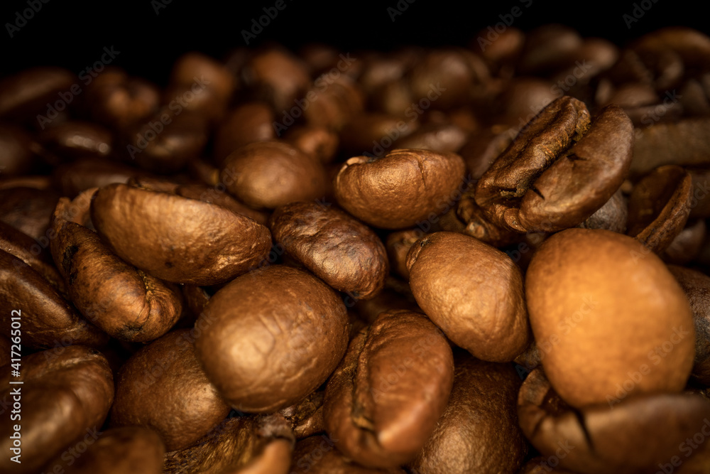 Naklejka premium Freshly roasted Coffee Beans - sliding macro shot